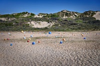 a beach with many colorful buoys in the sand